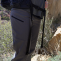 Medium close-up of a hiker wearing Outdoor Vitals Satu Adventure Pants on a trail, highlighting the zippered side pocket and comfortable waistband fit while carrying a backpack.